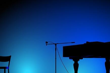 Umriss eines Klaviers auf einer Bühne mit blauem Hintergrund