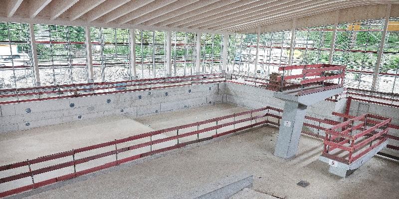 Weitläufiges Hallenbad, umgeben von einem roten Geländer, das die Schwimmfläche markiert.