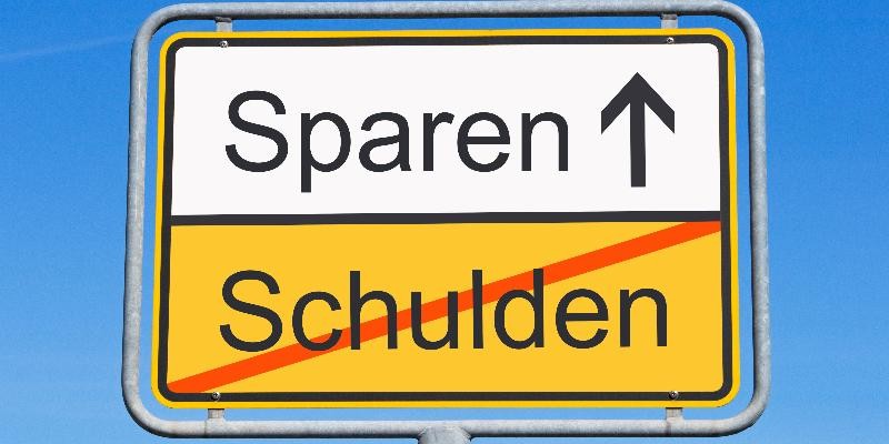 Schild mit der Aufschrift "Sparen" und "Schulden".