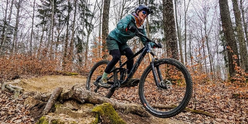 Mountainbikerin fährt auf einem Trail durch den Wald