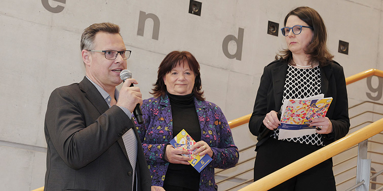 Dr. Carl-Gustav Kalbfell, Marion Merker und Yvonne Legner stehen auf einem Treppenabsatz in der Stadtbücherei