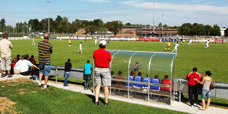 Zuschauer am Spielfeldrand verfolgen Fußballspiel am Sportpark Goldäcker