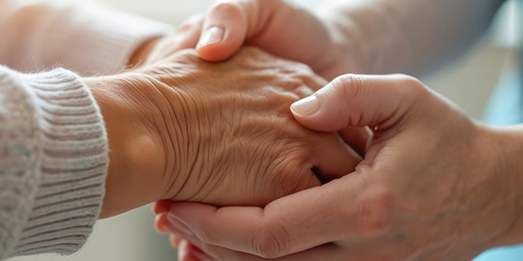 Hände halten die Hand eines älteren Menschen
