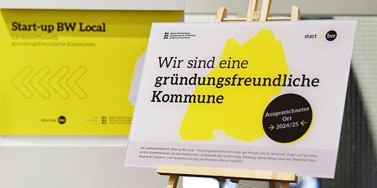 Plakat mit der Aufschrift „Wir sind eine gründungsfreundliche Kommune – Ausgezeichneter Ort 2024/25“ im Rahmen des Wettbewerbs „Start-up BW Local“
