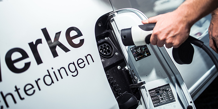 Elektrofahrzeug wird mit einem Ladekabel angeschlossen.