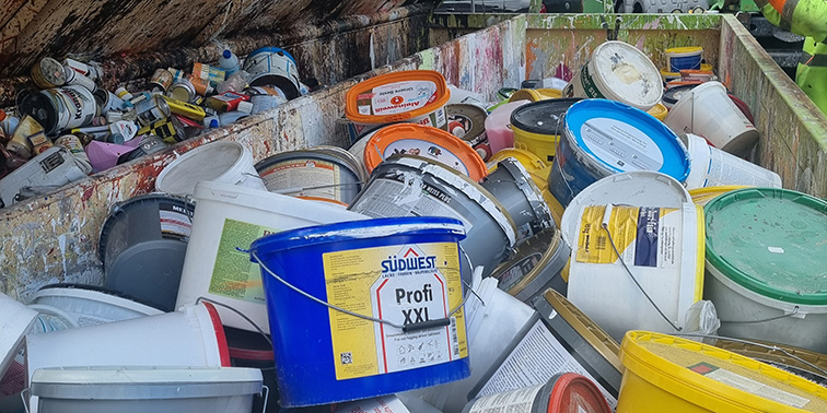 Container mit vielen alten Farb- und Lackeimern bei einer Schadstoffsammlung