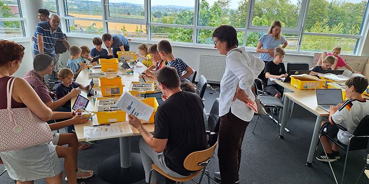 MINT-Kurs mit Kindern und Erwachsenen am Arbeitstisch