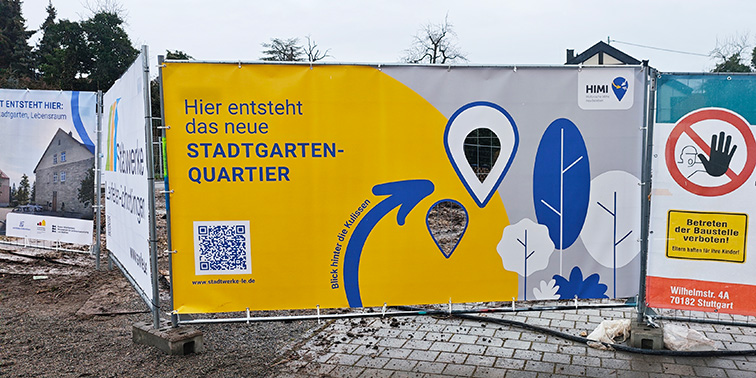 Banner an Bauzaun kündigt das neue Stadtgarten-Quartier in Leinfelden-Echterdingen an.