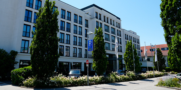 Hotelgebäude mit Parkanlage und Zufahrt.