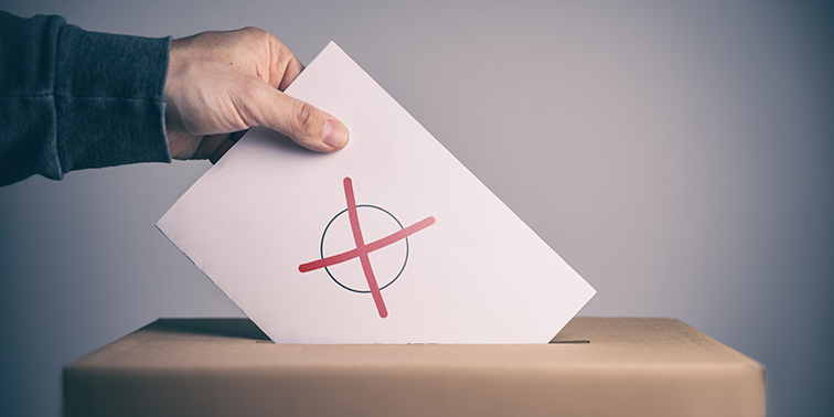 Wähler wirft Stimmzettel in Wahlurne