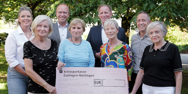 Acht Personen stehen im Freien und halten einen symbolischen Spendenscheck der Kreissparkasse Esslingen-Nürtingen über 1500 Euro.