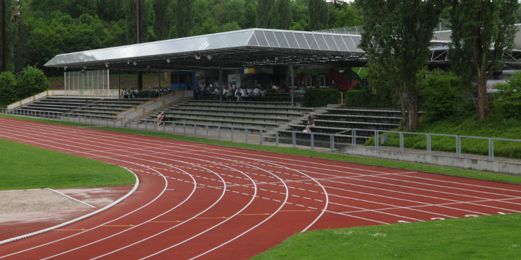 Rote Tartanbahn und Zuschauertribüne des Sportstadions Leinfelden