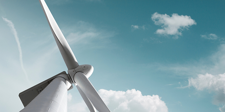 Windkraftanlage unter einem blauen Himmel mit leichter Bewölkung