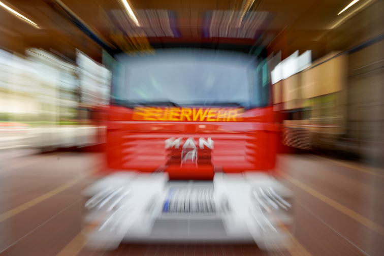 Front eines roten Feuerwehrfahrzeugs in Bewegung, unscharf durch Zoom-Effekt.