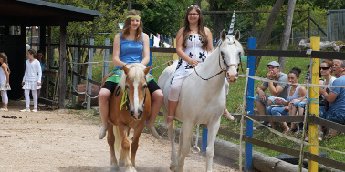 Zwei Teenager traben auf Pony und Pferd