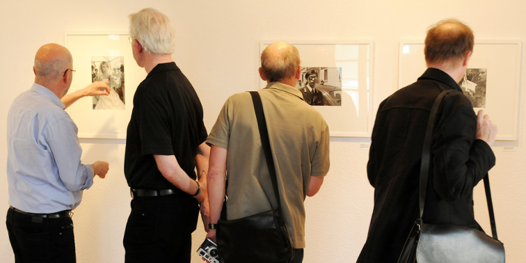 Menschen betrachten Bilder in einer Kunstgalerie